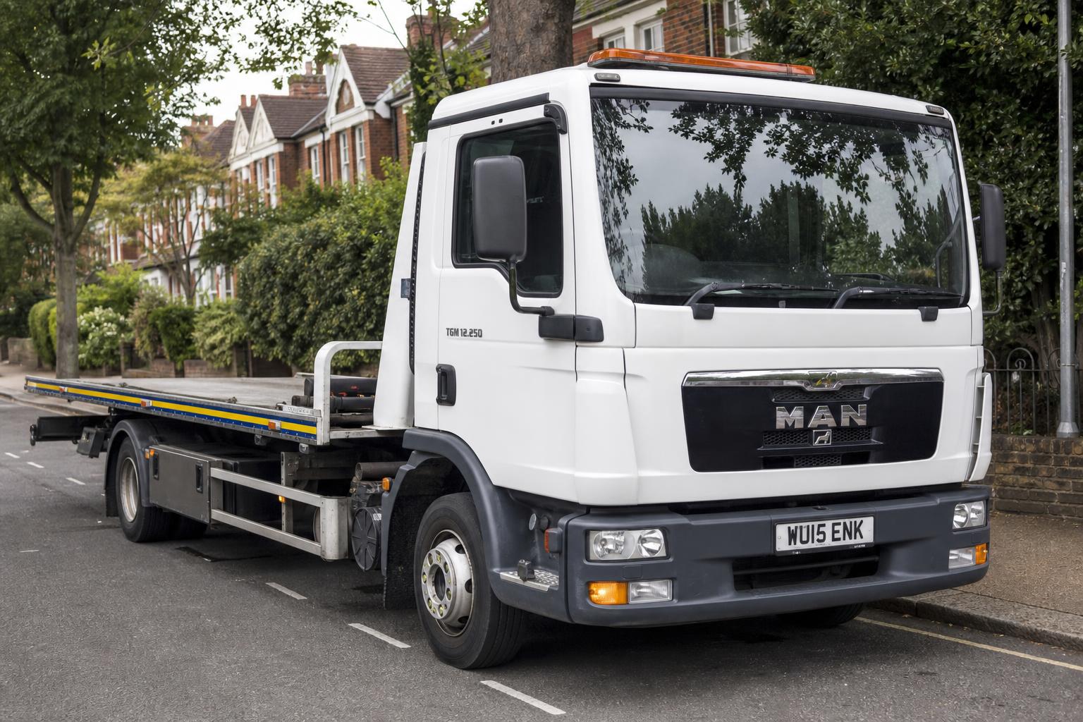 Swift Lift Recover flatbed recovery truck transporting a vehicle on a UK road